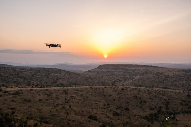 ケニア、ナイロビ、サンブルで美しい夕日と丘の上を飛んでいるドローン