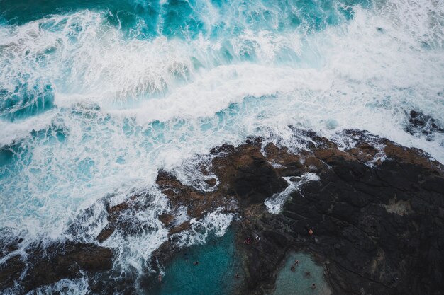 Вид с дрона на морские волны и скалистый берег