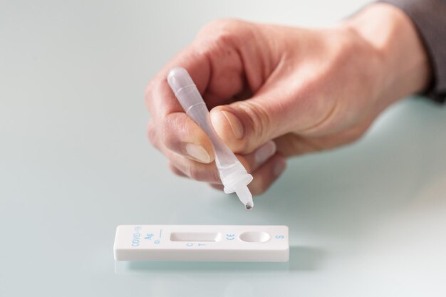 Covid-19抗原検査用の迅速検査カセットへの検査材料の滴下。医療の概念 Premium写真
