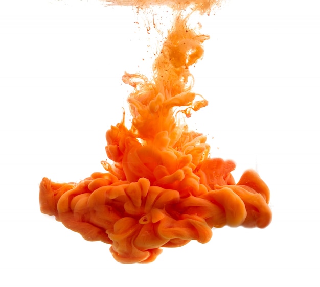 Drop of orange paint falling in water