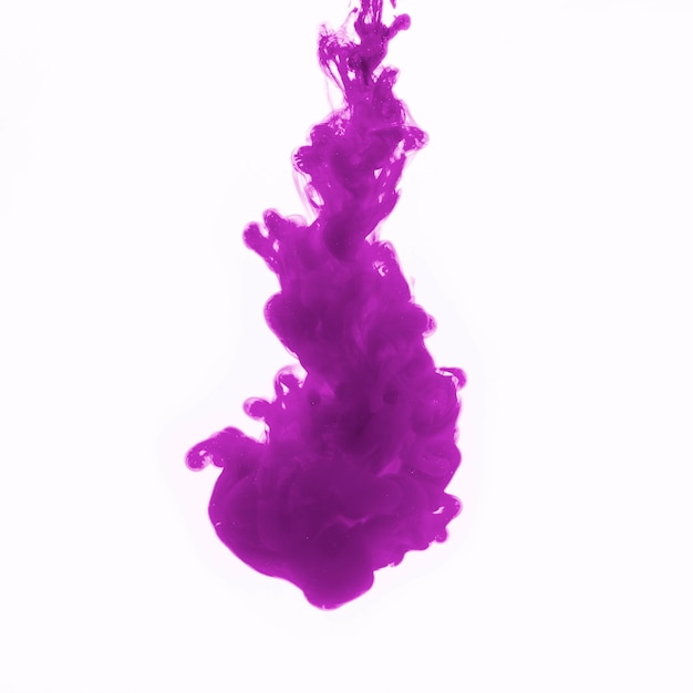 Капля фиолетового красителя в воде
