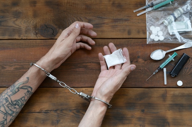 마약 밀매 자들이 헤로인과 함께 체포되었습니다. 수갑을 가진 경찰 체포 마약 상인