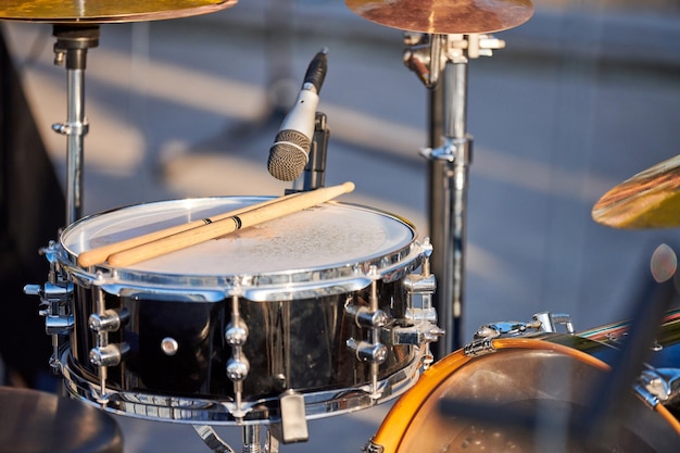 Барабанная установка на рок-вечеринке под открытым небом барабанные палочки на барабане томтом барабанная установка с барабанными палочками, готовая к игре на летнем рок-выступлении
