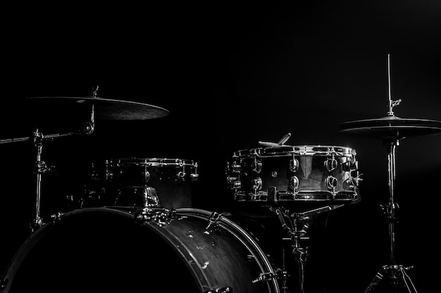 Drum kit on a dark background with stage lighting, copy space.