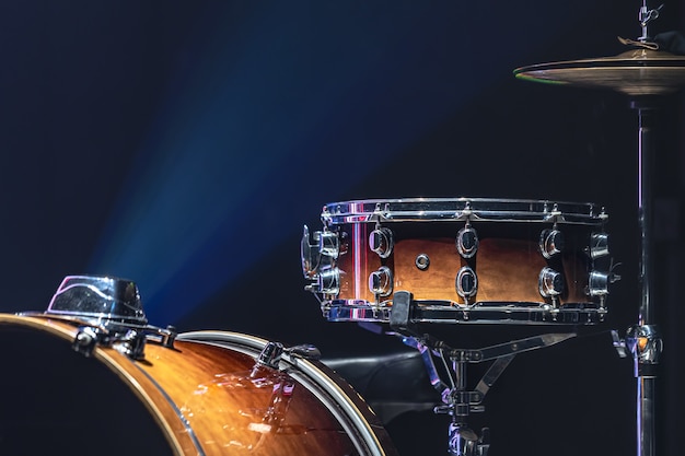 Free photo drum set in a dark room with beautiful lighting, snare drum, cymbals, bass drum.