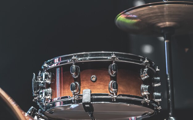 Drum set in a dark room with beautiful lighting, snare drum, cymbals.