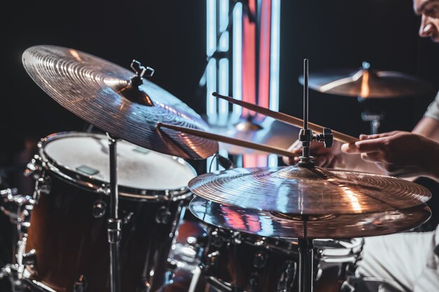 The drummer plays with beautiful lighting on a blurred background.