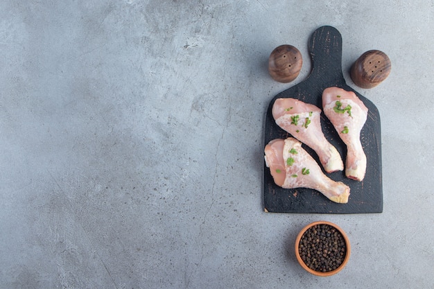 Drumsticks on a cutting board, on the marble background.