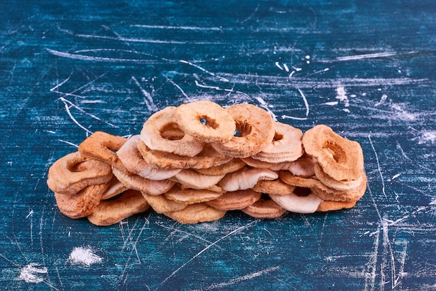 Dry apple slices on blue space, top view. 