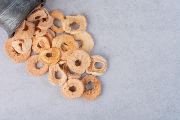 Dry apple slices out of a metallic pot. 