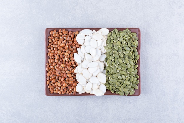 Dry assortment of legume and seeds on marble surface