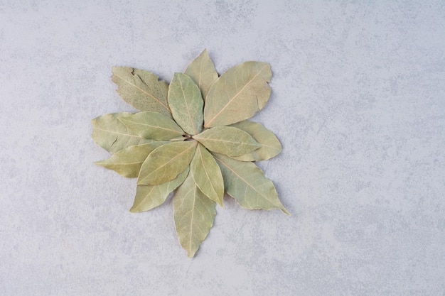 Free photo dry bay leaves on concrete background.