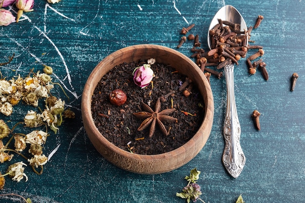 Dry black tea leaves in a wooden cup.