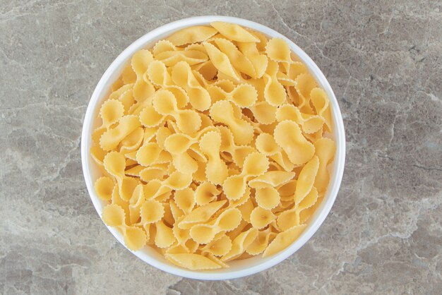 Dry bow pasta in white bowl