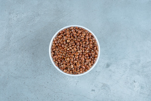 Dry brown beans in a white ceramic cup. High quality photo