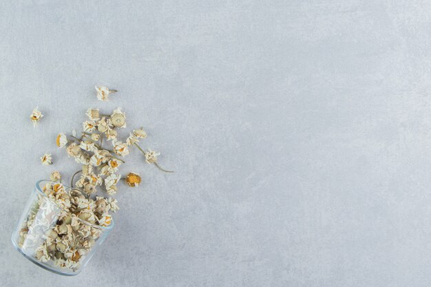 Dry chamomile flowers in glass bowl.  