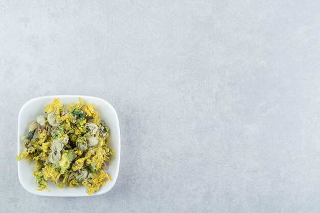 Dry chrysanthemum flowers in white bowl.  