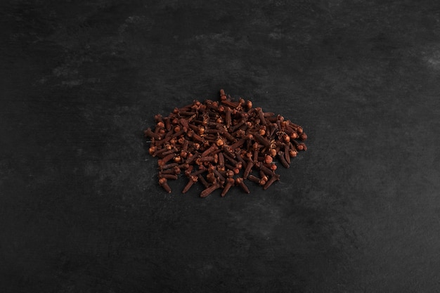 Free photo dry cloves isolated on black background.