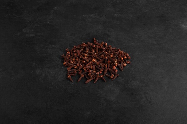 Free photo dry cloves isolated on black surface.