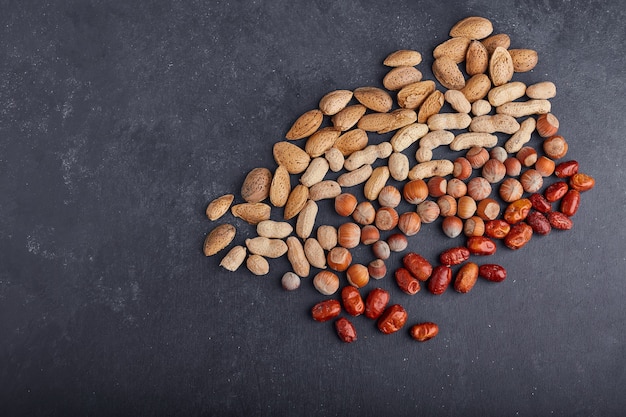 Dry fruits and beans on black background. 