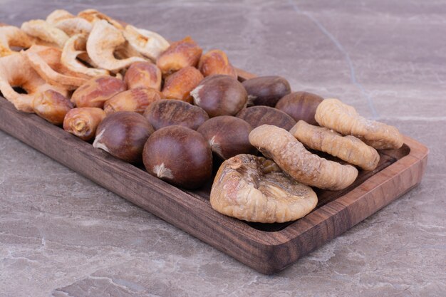 Dry fruits on a wooden platter on the stone