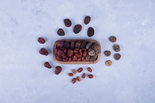 Dry fruits in a wooden platter and on the table