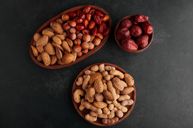 Dry fruits in wooden platters, top view. 