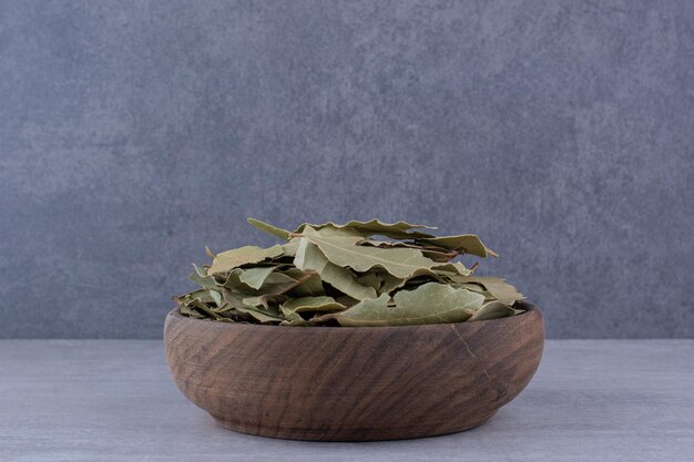 Free photo dry green bay leaves in a bowl on concrete background. high quality photo
