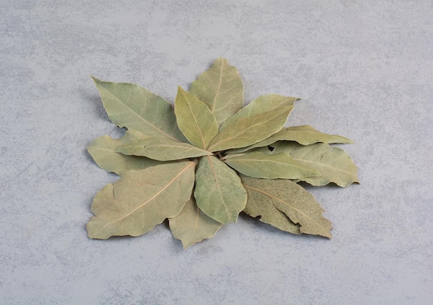 Free photo dry green bay leaves isolated on concrete background.