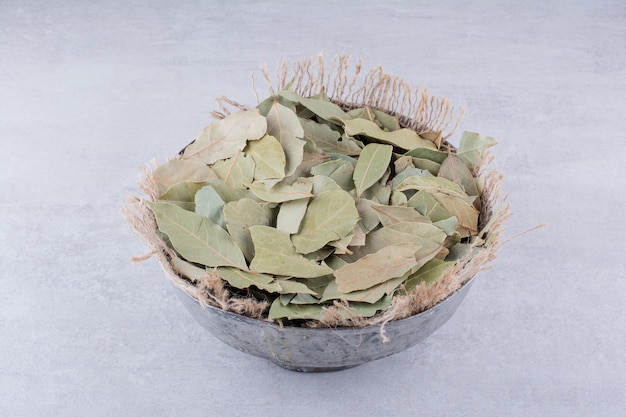 Free photo dry green bay leaves in a rustic cup. high quality photo