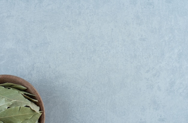 Free photo dry green bay leaves in a wooden cup. high quality photo