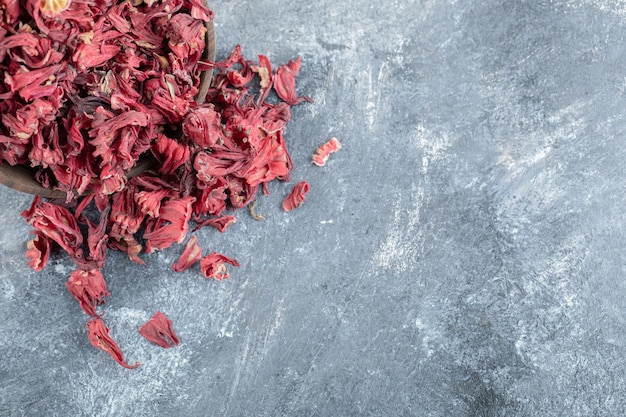 Dry hibiscus tea in wooden bowl.