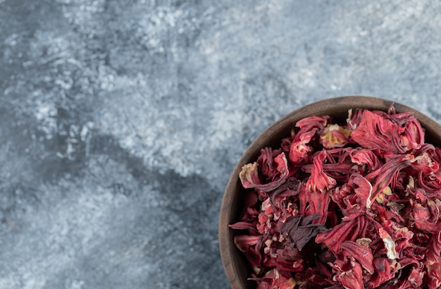 Dry hibiscus tea in wooden bowl. 