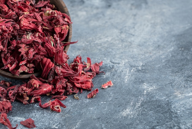 Dry hibiscus tea in wooden bowl. 