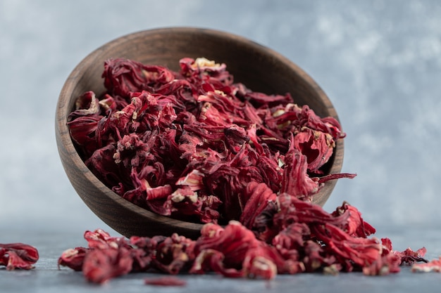 Dry hibiscus tea in wooden bowl. 