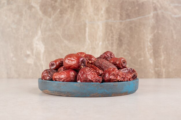 dry jujube berries on a rustic wooden platter.