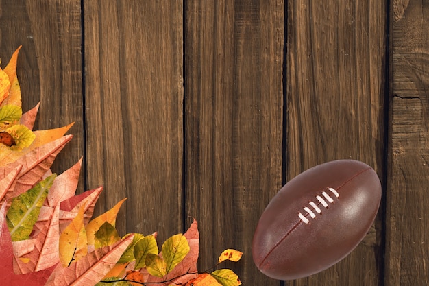 Dry leaves and rugby ball on a wooden floor