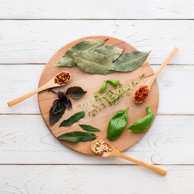 Dry leaves and spices on round wooden tray