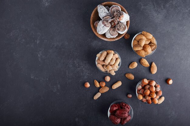 Dry nuts and fruits in a glass cup on grey background, top view. 