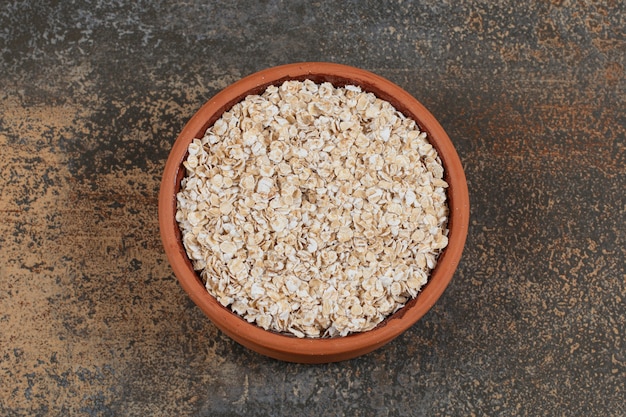 Dry oat flakes in ceramic bowl. 