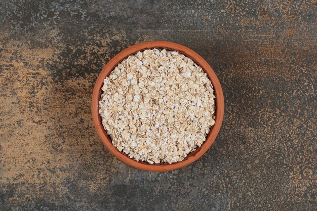 Dry oat flakes in ceramic bowl. 