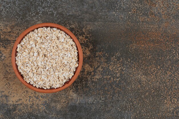 Dry oat flakes in ceramic bowl. 