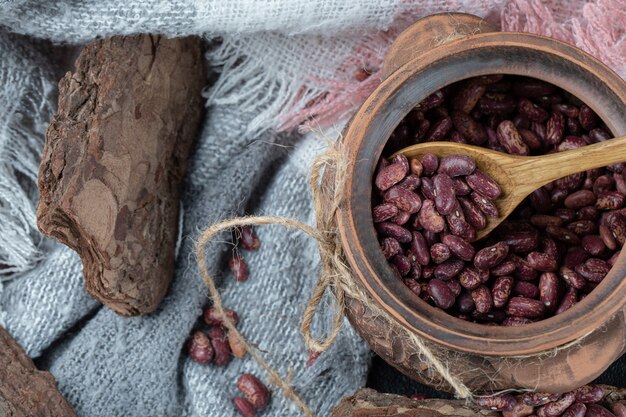 Dry red beans in classic mug with wooden spoon