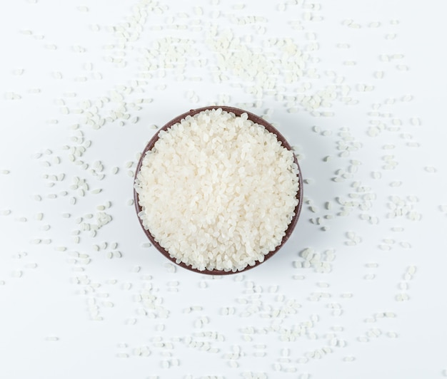 Dry round rice in a bowl top view on a white background