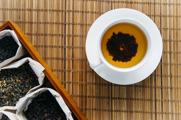 Dry tea herb with herbal tea on placemat