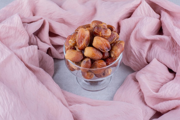 Dry yellow dates in a cup on concrete background. High quality photo