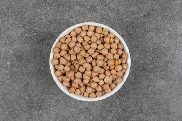 Dry yellow peas in white bowl.