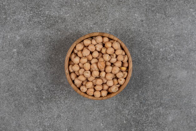 Dry yellow peas in wooden bowl.