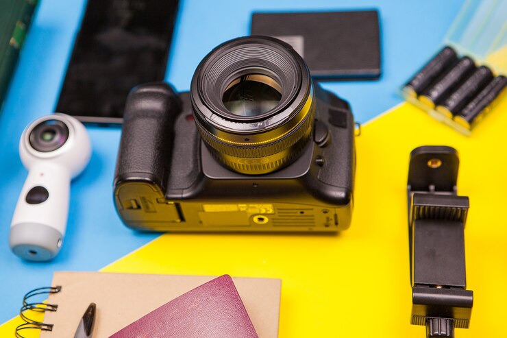 मुफ़्त फोटो dslr camera on two colored background next to different accesssories