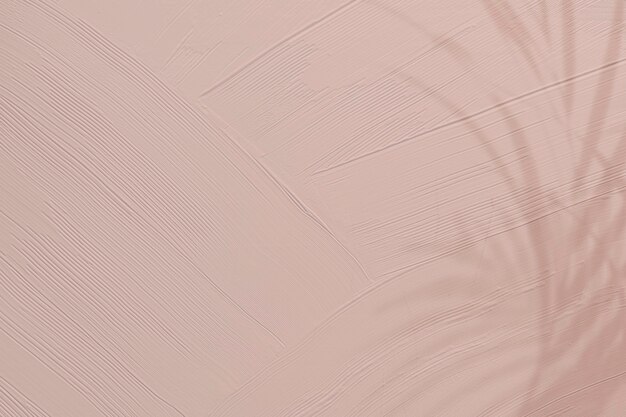 葉の影と鈍いピンクのペイントテクスチャ背景